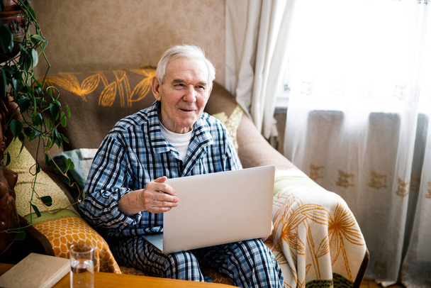Man smiling while looking at the laptop screen - Foto, Bild
