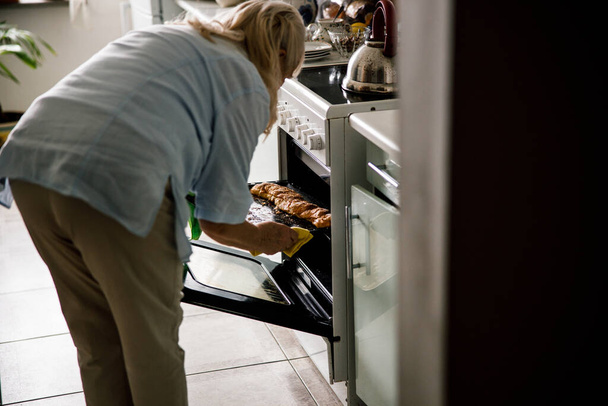 Housewife is baking herself-baked buns - Fotó, kép
