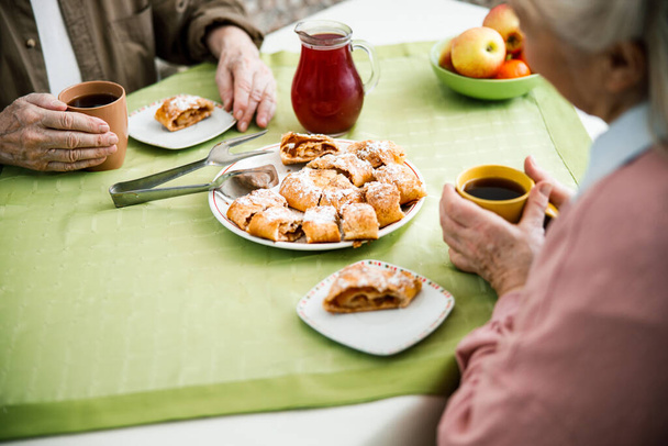 Elderly couple are warmed by cups of tea - Fotó, kép
