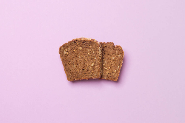 slice of bread luing on purple colored paper background. - Photo, image