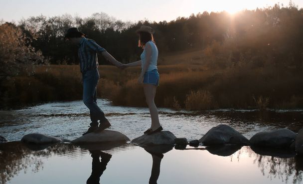 Пара молодых людей гуляют по осеннему лугу - Фото, изображение