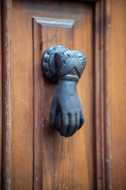 knocker in the shape of a knocking hand in black metal - Fotó, kép