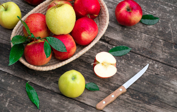 Red ripe apples in a basket on a wooden background - Φωτογραφία, εικόνα