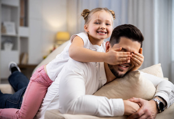 Daughter covering her dads eyes with a palm - Valokuva, kuva