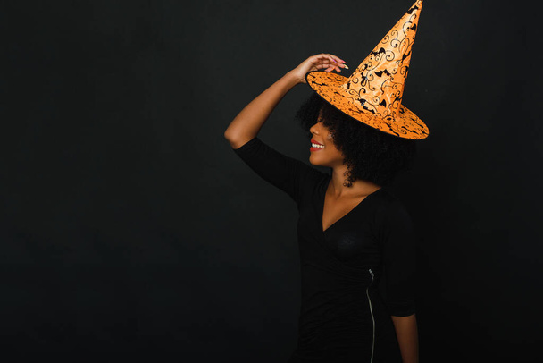 Siyah arka planda, cadılar bayramı kıyafetli Afrikalı Amerikalı bir kadın stüdyoda. Boşluğu kopyala - Fotoğraf, Görsel