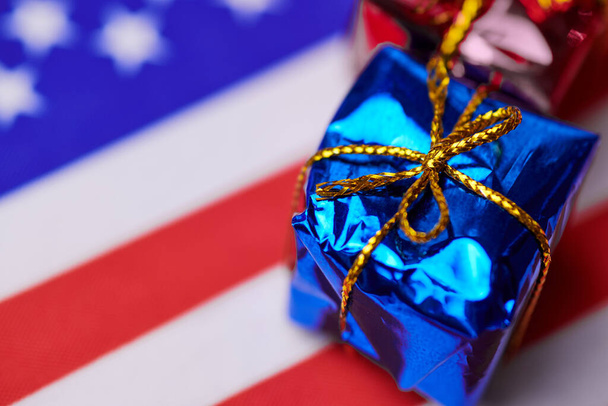 Geschenkkarton auf USA-Flagge. Amerikanisches Geschenk für die Nation. Grüne Karte oder Unabhängigkeitstag am 4. Juli USA präsentieren Konzept. - Foto, Bild
