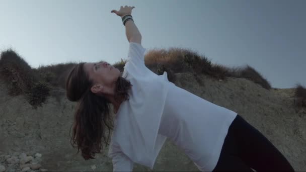Frau um die 40 praktiziert am frühen Morgen Yoga am Sandstrand - Filmmaterial, Video