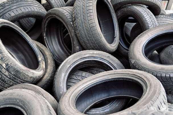 Waste tires no longer suitable for use on vehicles due to wear and are are among most problematic sources of waste. Editorial because of (barely) visible brand and model names - Photo, Image