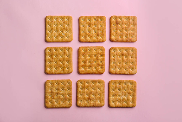 Delicious crackers on pink background, flat lay - Φωτογραφία, εικόνα