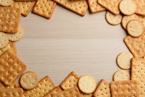 Frame of delicious crackers on wooden table, flat lay. Space for text - Valokuva, kuva