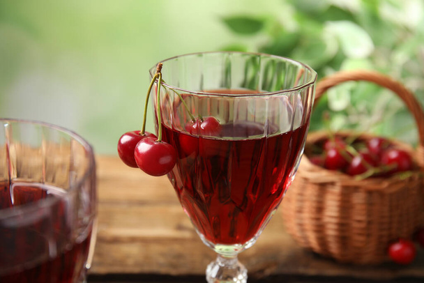 Delicious cherry wine with ripe juicy berries on table, closeup - Foto, Bild