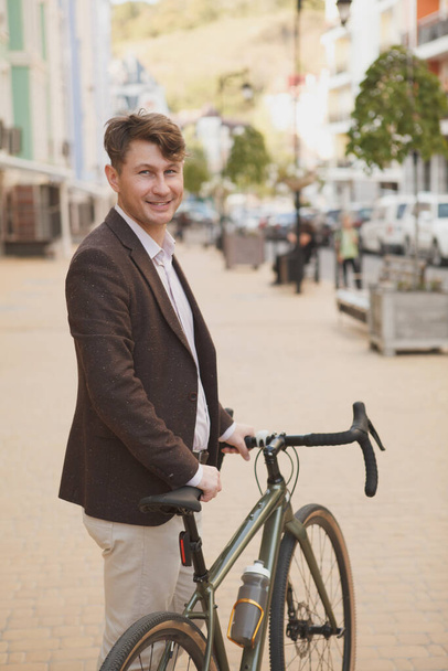 Vertical shot of a handsome stylish man using bicycle in the city - Foto, Imagem