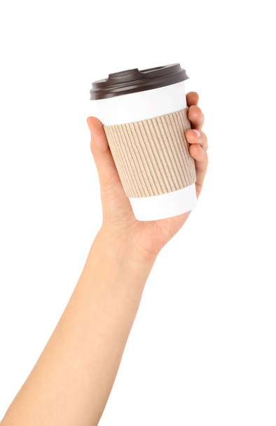 Woman holding takeaway paper coffee cup with cardboard sleeve on white background, closeup - Foto, imagen