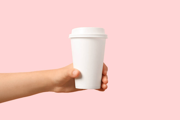 Woman holding takeaway paper coffee cup on pink background, closeup - Valokuva, kuva
