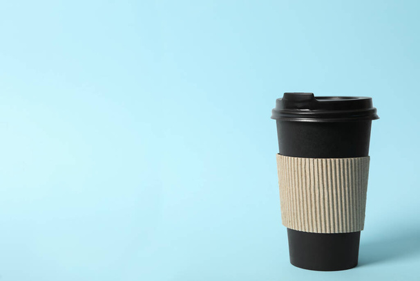 Takeaway paper coffee cup with cardboard sleeve on light blue background. Space for text - 写真・画像