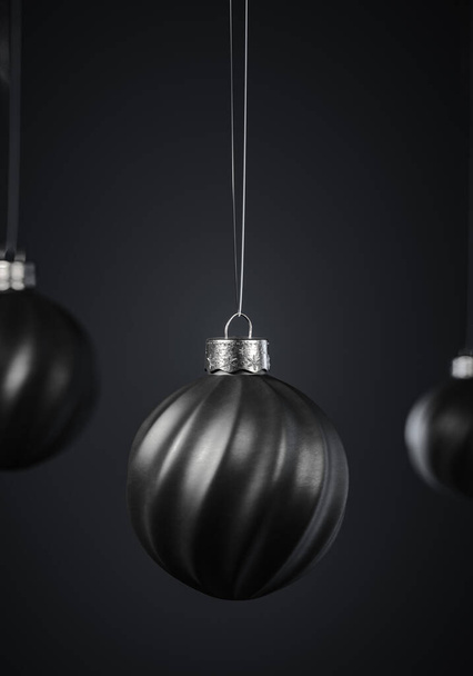 Üç çarpık çizgili siyah Noel topu koyu gri arka planda. Noel dekorasyonu, şenlikli atmosfer konsepti. Seçici odaklanma, portre yönelimi. - Fotoğraf, Görsel