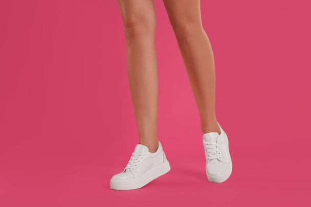 Woman wearing shoes on pink background, closeup - Foto, afbeelding