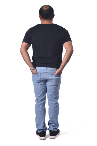 retrato de un hombre latino con la espalda con las manos en el bolsillo sobre fondo blanco - Foto, Imagen