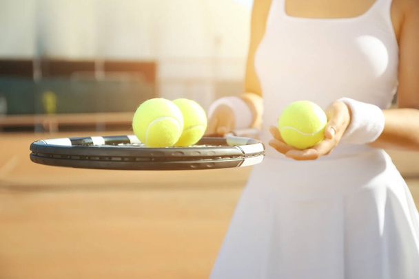 Sportswoman with racket and tennis balls at court, closeup - Fotografie, Obrázek