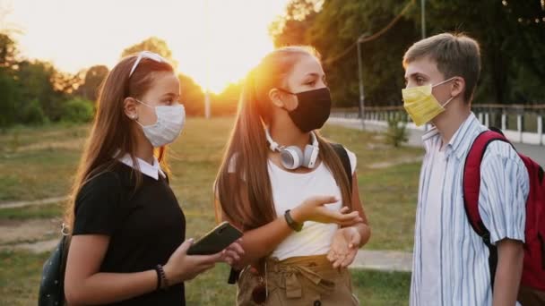 Comunicación de tres adolescentes con máscaras protectoras - Imágenes, Vídeo