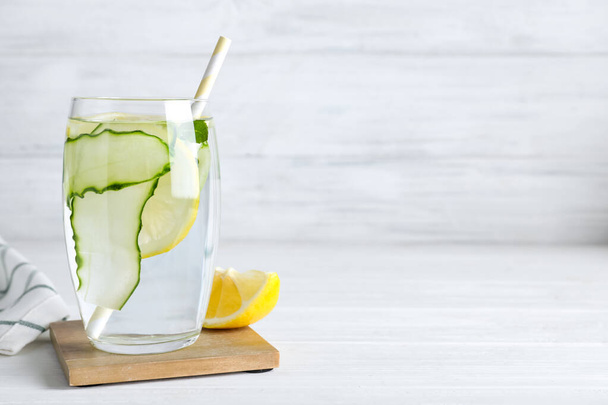 Refreshing water with cucumber, lemon and mint on white table, space for text - Fotografie, Obrázek