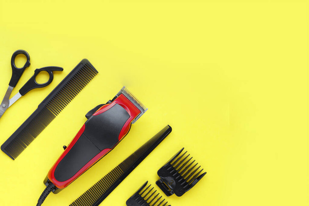 Friseurwerkzeug. Haarschneidemaschine in Nahaufnahme auf gelbem Hintergrund mit Düsen unterschiedlicher Größe. - Foto, Bild