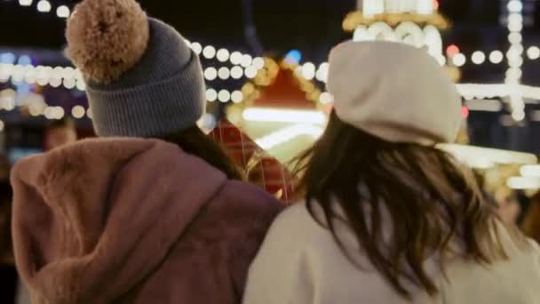Zadní pohled video ženy kráčející spolu přes vánoční trh. Snímek s RED heliovou kamerou v 8K.   - Záběry, video