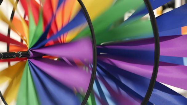 Colorful pinwheel spinning, weather wind vane, garden decoration in USA. Rainbow symbol of childhood, fantasy and imagination rotating. Multi colored spiral toy turning in breeze. Summertime dreaming. - Photo, Image