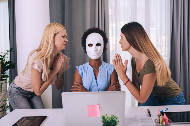 Giovani donne d'affari che lavorano insieme in ufficio. Una donna indossa una maschera. - Foto, immagini