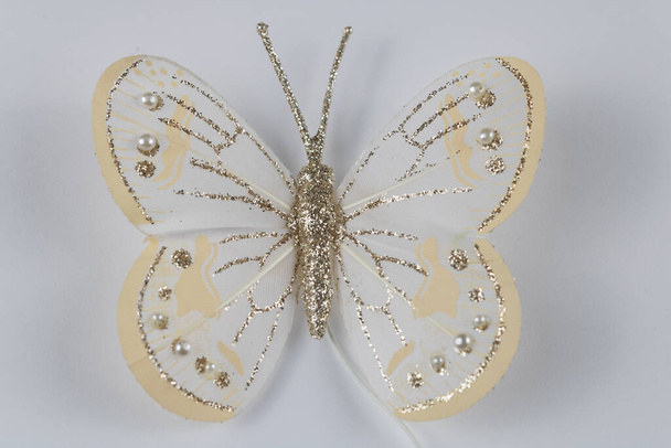 witte vlinder met glitter op een witte achtergrond. Kerstversiering - Foto, afbeelding