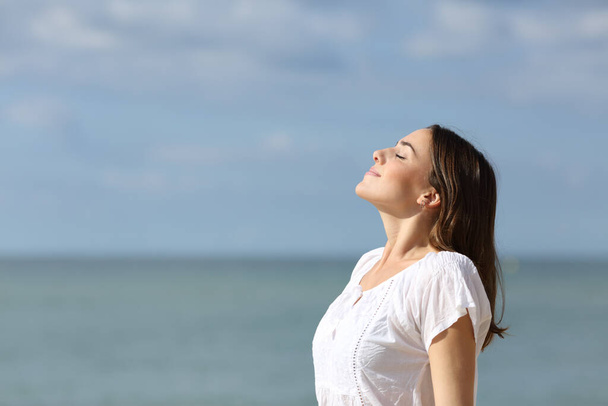 Profile of a relaxed teen breathing fresh air on the beach a sunny day of summer - Φωτογραφία, εικόνα