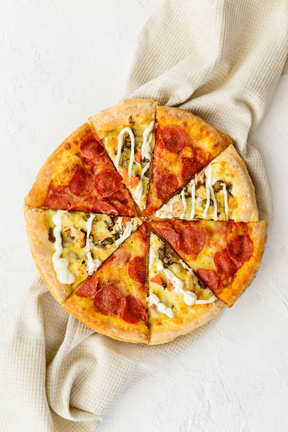 Pizza különböző darabokból vászontörölközőn. Függőleges tájolás, felülnézet, lapos fekvés. - Fotó, kép