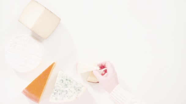 Varietà di cunei di grandi dimensioni formaggio gourmet su sfondo bianco. - Filmati, video
