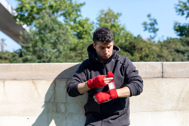 Boxer preparing for training with forearm bandage outdoors - Foto, Imagem