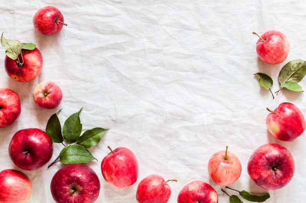 Ripe Red Apples with Leaves, Wrinkled White Cloth Background, copy space for your text - Foto, Imagem