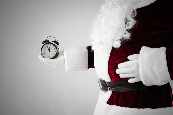 Santa Claus holding alarm clock on light grey background, closeup. Christmas countdown - Foto, Imagem