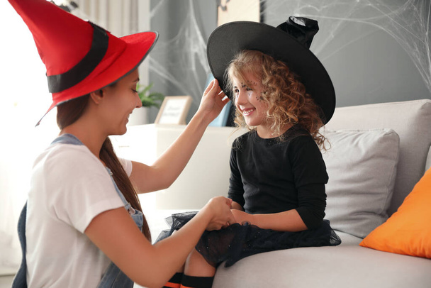 Mother and cute little girl wearing Halloween costumes at home - Foto, Imagem