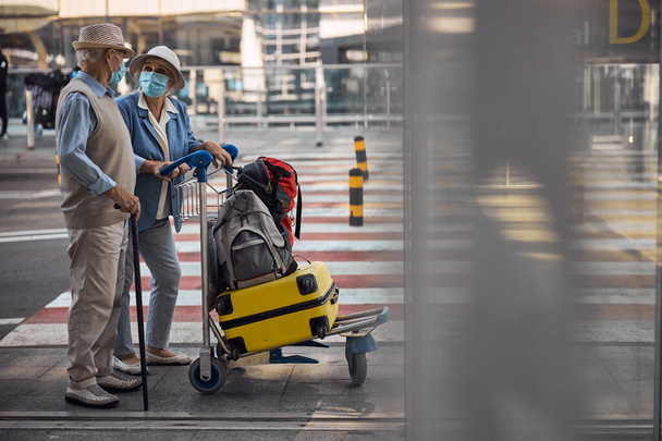Viajeros de pie en la entrada de la terminal del aeropuerto - Foto, imagen