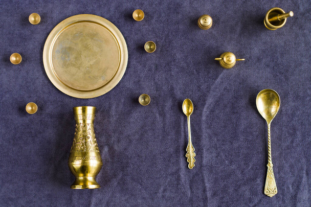Masanın üzerinde altın antika bulaşık takımı, küçük nesneler. - Fotoğraf, Görsel