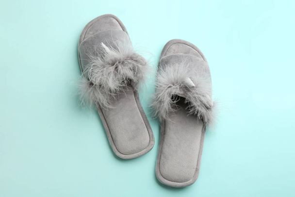 Pair of stylish soft slippers on turquoise background, flat lay - Photo, image