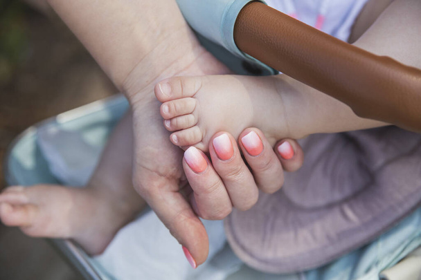 Moeder houdt haar dochter 's kleine baby voet - Foto, afbeelding