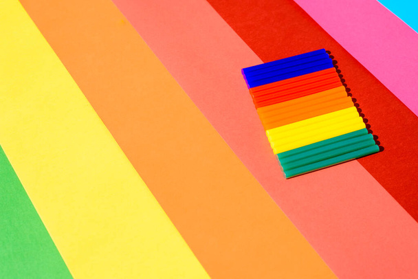 Pegamento de silicona colorido se pega sobre un fondo de líneas vibrantes. - Foto, imagen