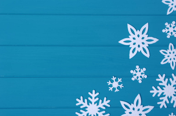 Snowflakes and stars on a blue wooden background - Valokuva, kuva