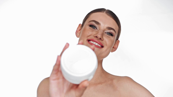 Boldog fiatal felnőtt nő nyitó tartály kozmetikai krém elszigetelt fehér - Felvétel, videó