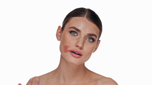 Jeune femme adulte enlever rouge à lèvres avec la main isolé sur blanc - Séquence, vidéo