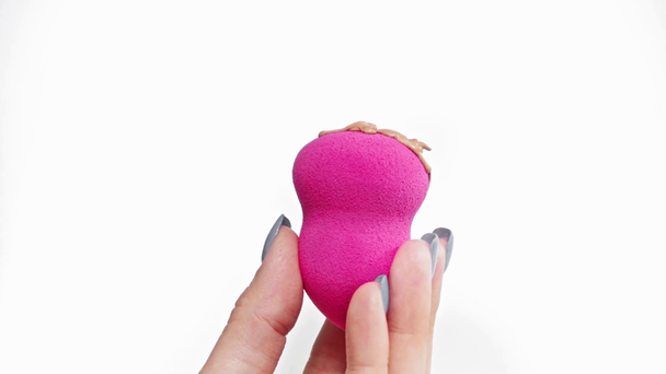 cropped view of woman holding beauty blender with foundation isolated on white - Footage, Video