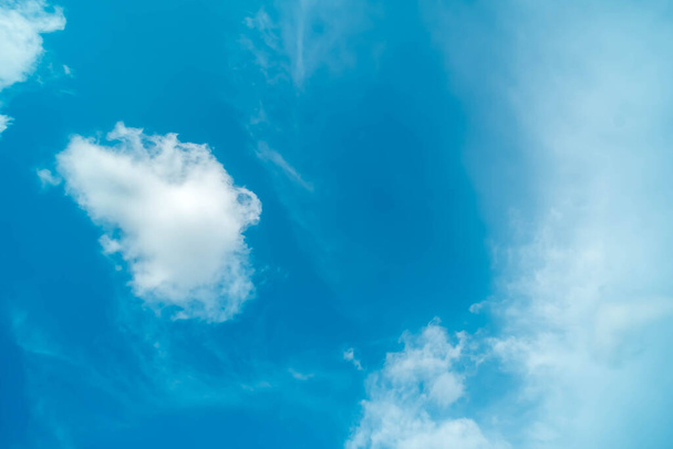 White fluffy clouds against blue sky in summer nature season weather background - Foto, Imagen