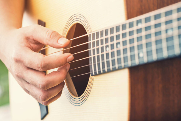 руки людини грають на акустичній гітарі
 - Фото, зображення