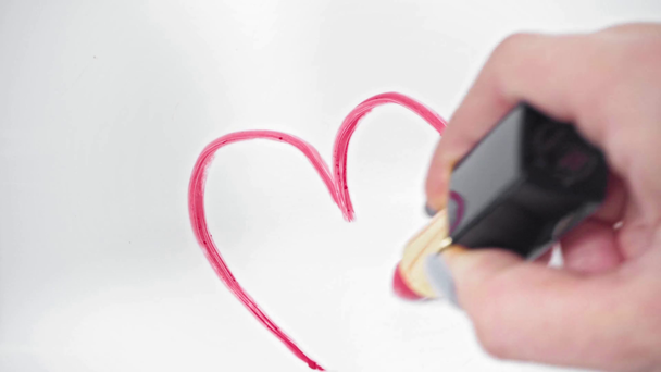 Close up άποψη της γυναίκας σχέδιο σύμβολο της καρδιάς με ροζ κραγιόν σε λευκό - Πλάνα, βίντεο