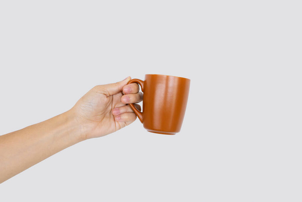 closeup hand holding cup of coffee in white background with soft-focus and over light in the background - Foto, Imagem